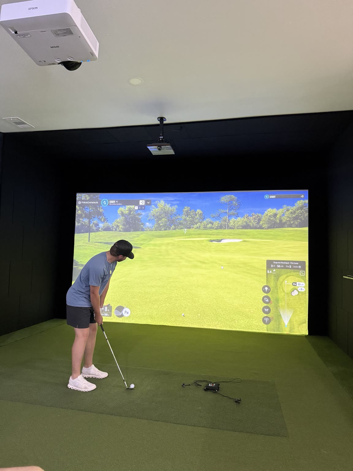Simulator impact screen showing a projected fairway with shot tracer and metrics